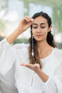 A woman holding a crystal for chakra healing, focusing on spirituality and wellness.